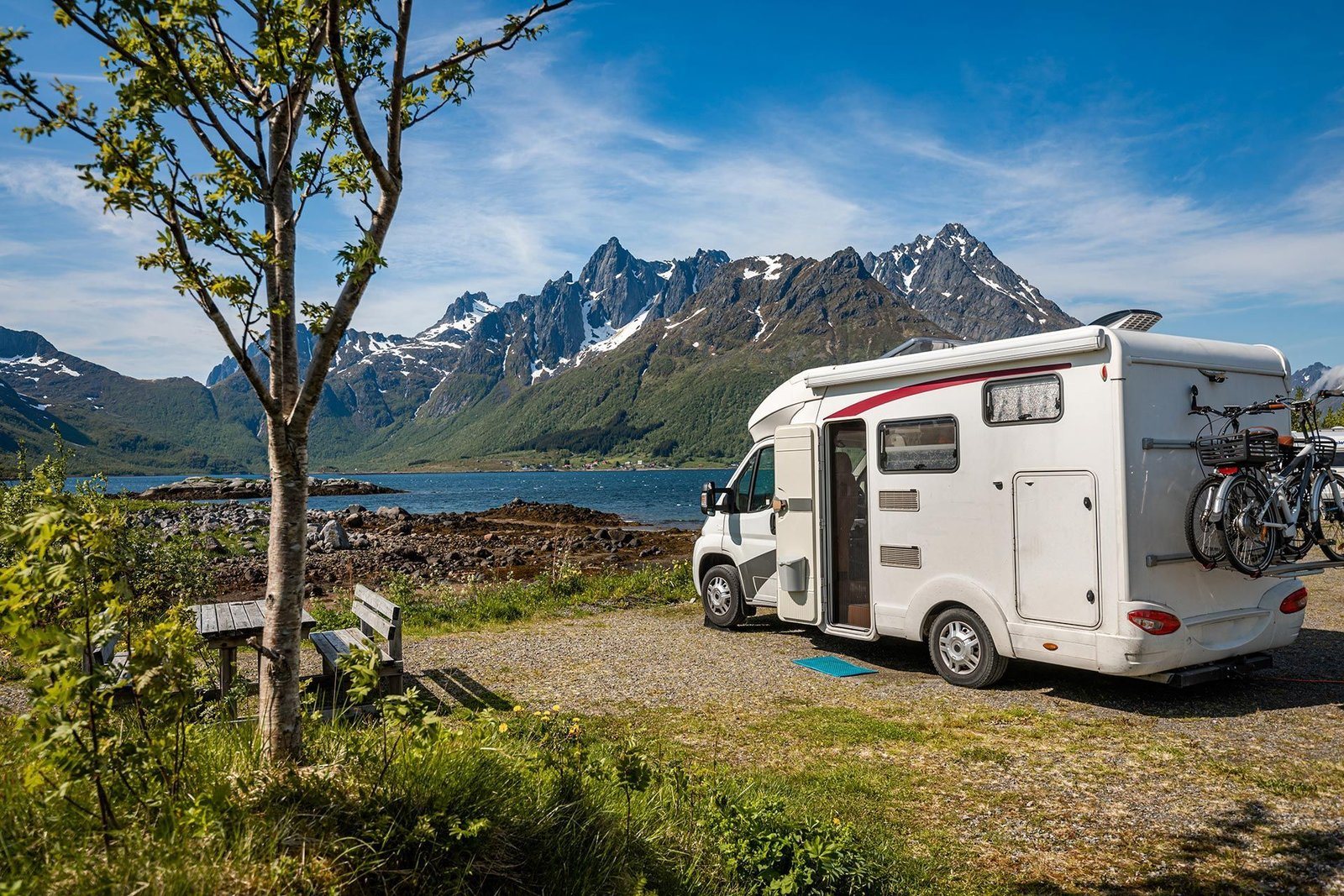 Camper aan een meer met een berglandschap op de achtergrond